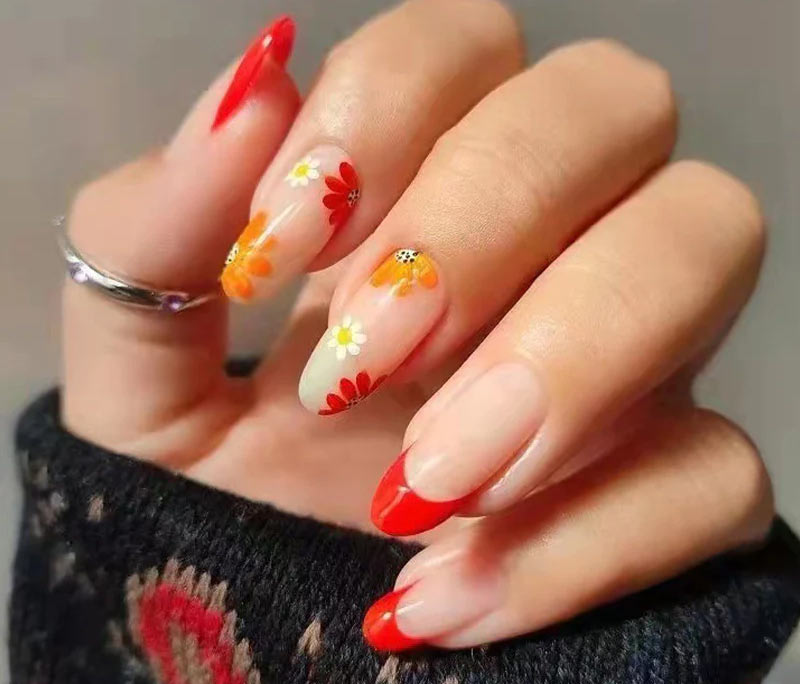 Mẫu nail hoa cúc màu đỏ và cam rực rỡ đôi bàn tay